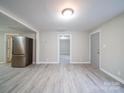 Open kitchen and dining area with gray wood-look flooring and stainless steel appliances at 208 Oakland Dr, Lowell, NC 28098