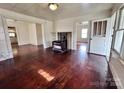 Living room with hardwood floors, wood burning stove, and built-in shelving at 703 Buffalo St, Shelby, NC 28150