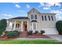 Two-story house with beige siding, a covered porch, and a brick walkway leading to the front door at 7750 Trailridge Dr, Tega Cay, SC 29708