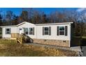 Ranch style home with light beige siding, gray shutters, and a brick base at 145 Eastgate Dr, Statesville, NC 28625