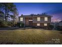 Inviting two-story home with a well-lit exterior and front yard at dusk at 15625 Fairfield Dr, Matthews, NC 28104