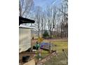 Backyard of a house with a metal rooster decoration, trees, and distant hills at 206 Rocky Top Rd, Taylorsville, NC 28681