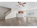 Spacious living area with wood-look floors, ceiling fan, and staircase at 5622 Grey Dogwood Ct, Charlotte, NC 28269