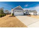 Gray house with white garage doors, landscaping, and a sunny day at 139 Commerce Blvd, Lancaster, SC 29720