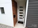 Front door with decorative glass panels and a wood accent wall at 327 Coxe Ave, Charlotte, NC 28208