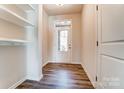 Welcoming foyer with built-in shelving, coat hooks, and wood-look flooring at 14906 Tamarack Dr, Charlotte, NC 28278