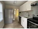 Bright and airy kitchen with white cabinets, stainless steel appliances, and a stylish backsplash at 2704 Remington St, Charlotte, NC 28216