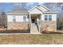 Inviting home exterior with stone accents, covered entryway, and front yard at 5120 Kings Pinnacle Dr, Kings Mountain, NC 28086