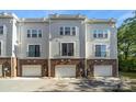 Rear view of townhomes featuring balconies, attached garages, and paved driveways at 547 Old Mill Rd, Charlotte, NC 28206