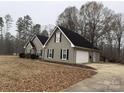 Side view of a home with a garage, driveway, and trees at 13410 Old Camden Rd, Midland, NC 28107