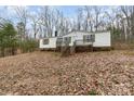 Mobile home exterior on a sloped lot with leaf covered ground at 326 Chestnut Ridge Rd, Kings Mountain, NC 28086