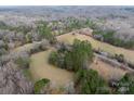 An aerial view showcasing a house amidst a sprawling landscape of trees and fields at 3713 Capricorn Rd, Lancaster, SC 29720