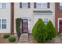 Townhouse entrance with red door, landscaping, and brick exterior at 9533 Brackenview Ct, Charlotte, NC 28214