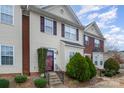 Two-story townhouse with brick and siding, featuring landscaping and a red door at 9533 Brackenview Ct, Charlotte, NC 28214