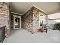 Covered front porch with stone accents, a bench, and decorative wreath at 1410 Morningmist Ct, Marvin, NC 28173