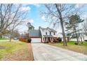 Two-story home with brick and siding exterior, driveway, trees, and fenced yard at 2916 Waycross Dr, Monroe, NC 28110