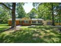 Front exterior of a single Gathering home with lush green grass, mature trees, and an attached garage at 3201 Oscar Dr, Matthews, NC 28105