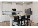 Modern kitchen with white cabinets, stainless steel appliances, and an island with bar seating at 1103 Harry Ct, Albemarle, NC 28001