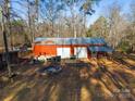 Red metal storage building with double doors and covered porch at 5040 Spicewood Dr, York, SC 29745