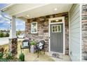 Welcoming front porch with gray door, stone accents, and seating area at 6283 Tea Olive Dr # 175, Harrisburg, NC 28075