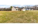 Front and side view of a house with a sloped front yard and a few trees in the background at 8695 Freeze Rd, Kannapolis, NC 28081