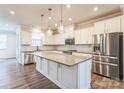 Modern kitchen with white cabinets, large island, and stainless steel appliances at 16744 Summers Walk Blvd, Davidson, NC 28036