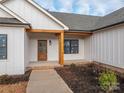 Front entry with wooden post and door, stone accents and landscaping at 2596 Maiden Salem Rd, Lincolnton, NC 28092