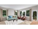 Cozy living room featuring a teal sofa and two brown armchairs, with access to a deck at 7932 Cedarsmith Ct, Charlotte, NC 28217