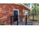 Brick home's front entrance with black door and fence at 1327 F Se Ave, Hickory, NC 28602