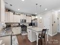 Spacious kitchen featuring white cabinets, granite countertops, and a large island at 7543 Hamilton Bridge Rd, Charlotte, NC 28278