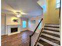 Living room with hardwood floors, fireplace, and staircase at 9718 Mitchell Glen Dr, Charlotte, NC 28277