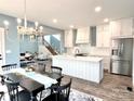 Open concept kitchen with white cabinets, a large island, and stainless steel appliances at 122 Arrowood Ln, Harmony, NC 28634