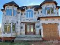 Two-story house with gray roof and large windows under construction at 16612 Blackberry Hills Dr, Midland, NC 28107