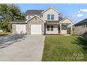 Two-story house with stone accents and a three-car garage at 4448 Triumph Sw Dr, Concord, NC 28027