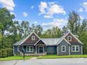 Gray house with wood accents, landscaped lawn, and a walkway leading to the entrance at 2694 Woodcrest Sw Dr, Concord, NC 28027