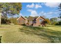 Brick ranch home nestled on a spacious lot with mature trees and lush grass at 4330 Whitetail Ln, Midland, NC 28107