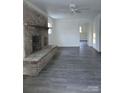 Living room with brick fireplace and gray laminate floors at 111 Dye St, Chester, SC 29706