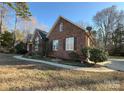 Side view of brick home showcasing the landscaping and walkway at 900 Brighton Dr, Kannapolis, NC 28081