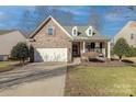 House with stone and shingle exterior, two-car garage, and neat landscaping at 1160 Bontrager Trl, Fort Mill, SC 29715