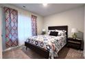 Cozy bedroom with patterned bedding and ample natural light at 1401 Nia Rd, Charlotte, NC 28215
