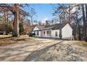 White house with red door and driveway, nestled among trees at 1919 Crooked Creek Dr, Charlotte, NC 28214
