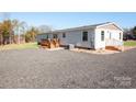 Home exterior showcasing a gravel driveway and landscaping at 816 Perry Rd, Troutman, NC 28166