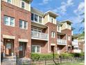 Three-story brick townhome community with balconies and landscaping at 1420 W 4Th St, Charlotte, NC 28208