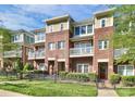 Three-story brick townhome with balconies and a fenced front yard at 1420 W 4Th St, Charlotte, NC 28208