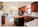 Updated kitchen with wooden cabinets, live-edge island, and stainless steel appliances at 190 Heathergate Ln, Stanley, NC 28164