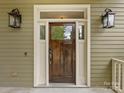 Elegant dark wood front door with sidelights and lanterns at 15710 Laurel Oak Cres, Davidson, NC 28036