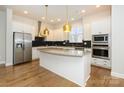 Modern kitchen with white cabinets, granite island, and stainless steel appliances at 7542 Waverly Walk Ave # 7542, Charlotte, NC 28277