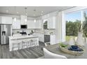 Open kitchen with white cabinets, island, stainless steel appliances, and gray flooring at 7224 Hodges Meadow Ln, Charlotte, NC 28213