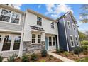 Two-story townhome with light gray and navy siding, stone accents, and a teal front door at 2009 Near Point Rd # 21, Charlotte, NC 28208