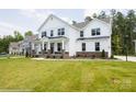 Two-story white house with stone accents and a landscaped lawn at 3240 Mcharney Dr # 36, Harrisburg, NC 28075